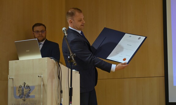 Prof. Robert Smoleński prezentuje dokument potwierdzający uzyskanie doktoratu przez Hermesa Josego Loschiego, fot. K. Adamczewski